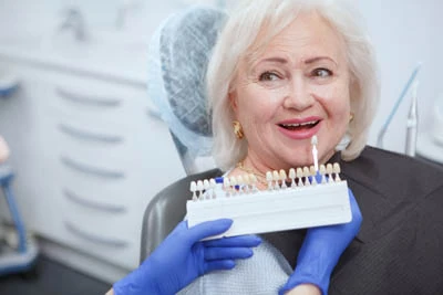 woman choosing a color for her dental veneers