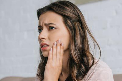 woman hurting due to tooth pain